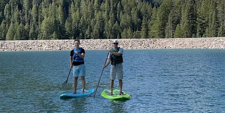 two guys on paddleboards by the lake
