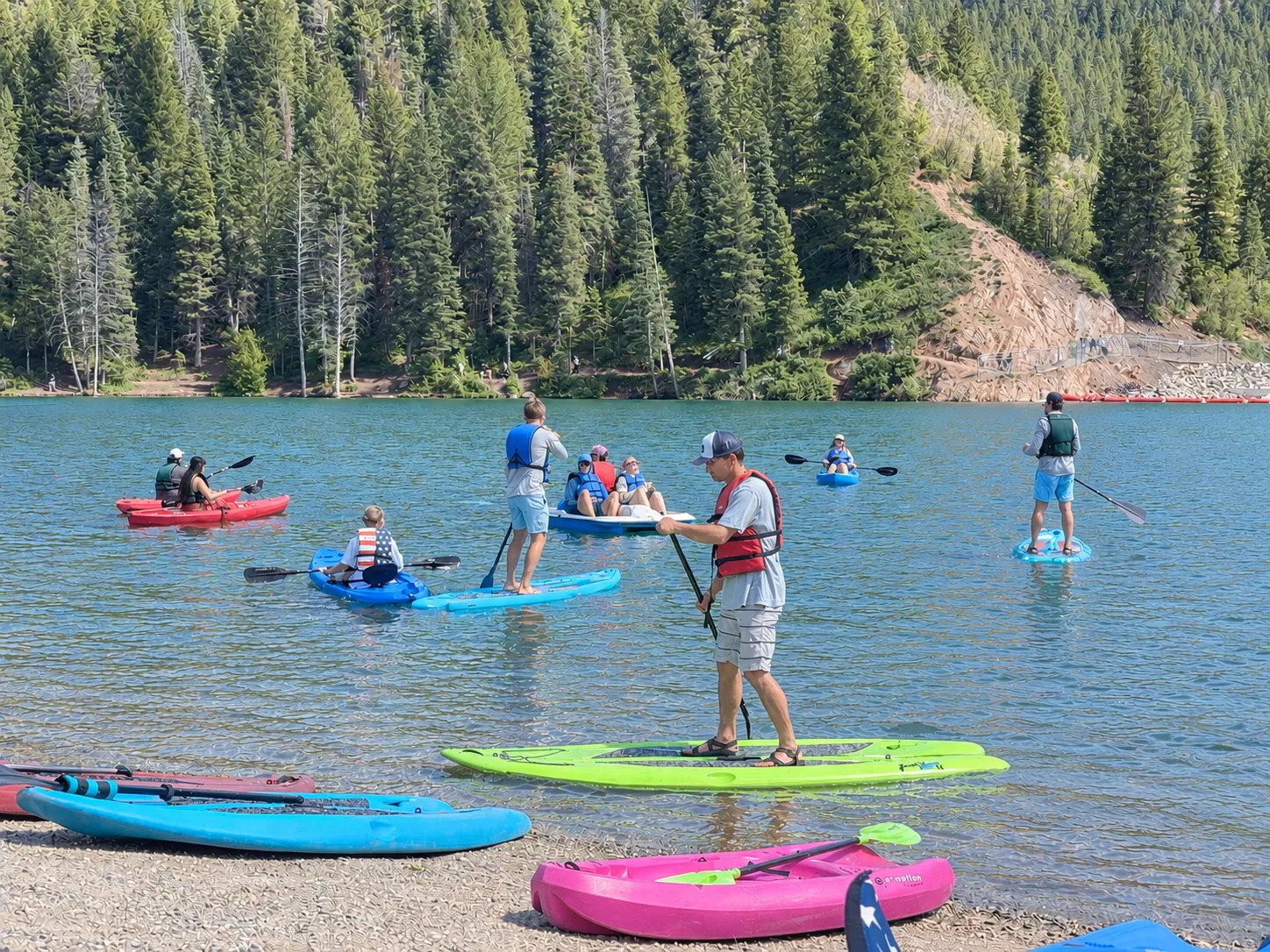 Family at the lake on paddleboards and kayaks