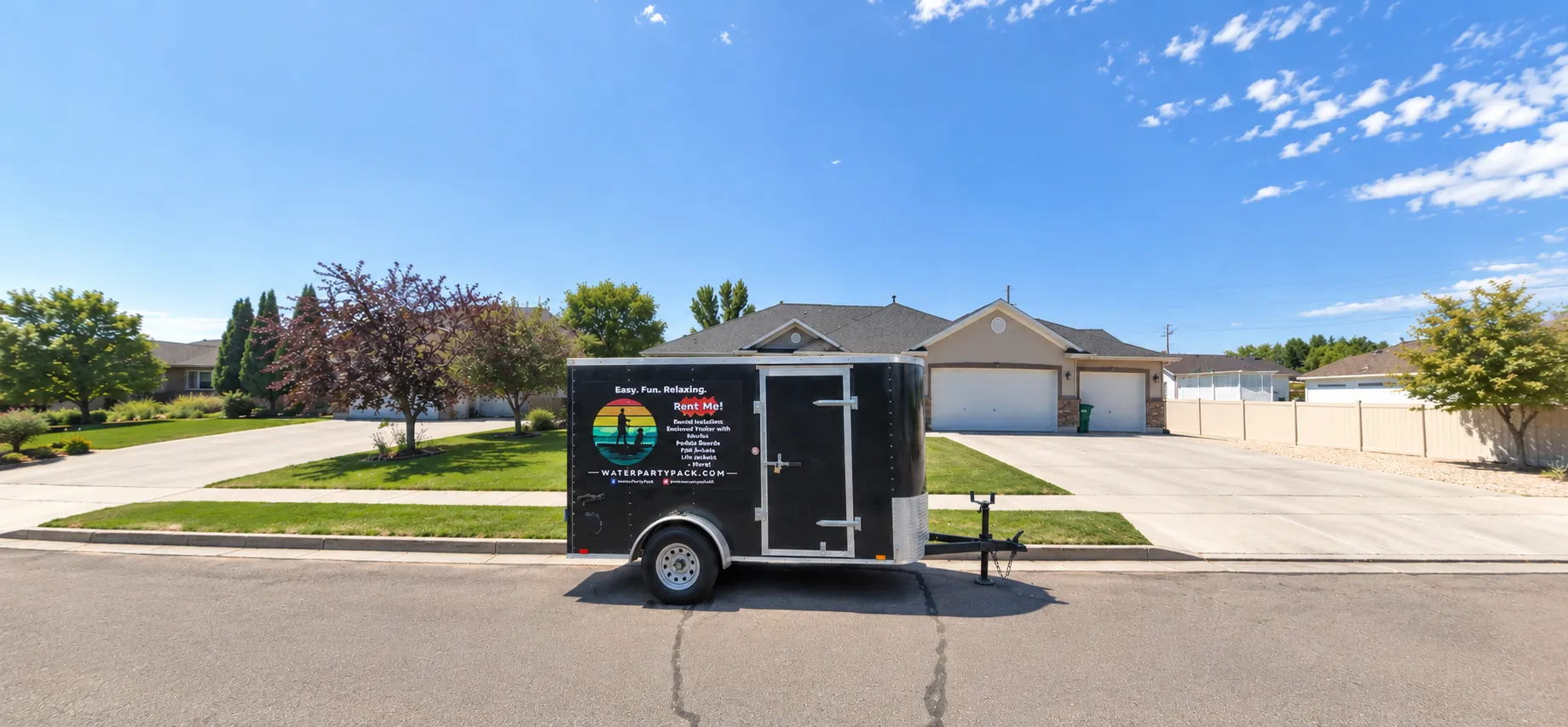 A black enclosed Water Party Pack rental trailer parked along a residential curb in front of a house, with the company’s colorful logo and rental information displayed on the side.